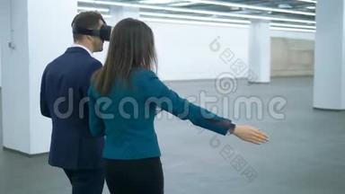 女房地产经纪人正在向一位穿着VR眼镜的商人展示一个空大厅。 <strong>商业地产</strong>。